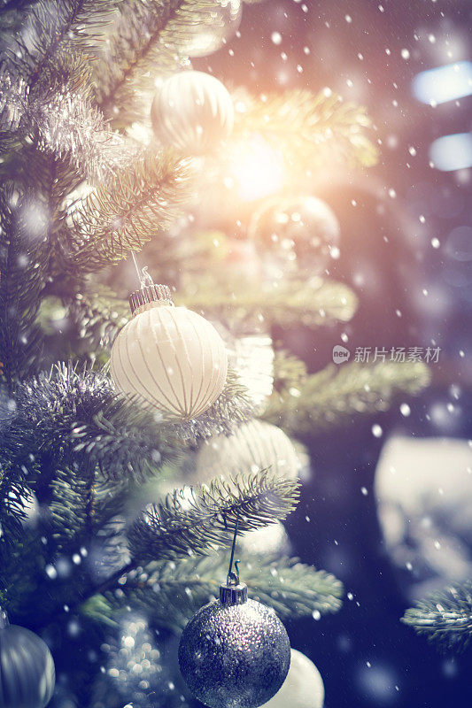 白色和银色的小装饰品挂在装饰好的圣诞树上。
