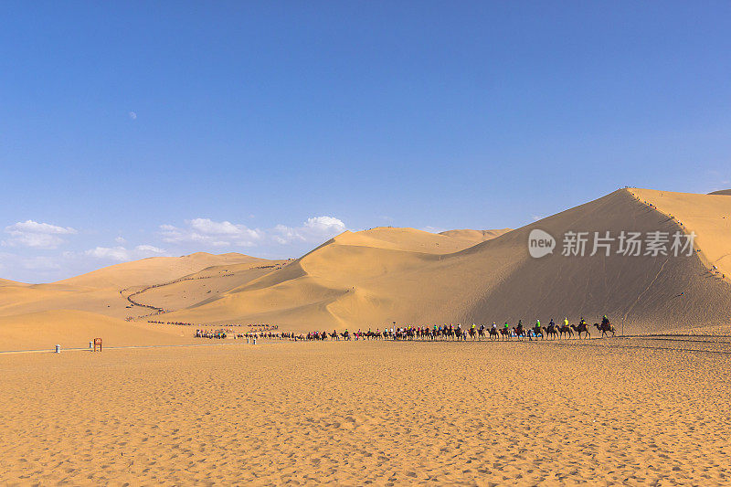 中国敦煌——2014年8月6日:中国敦煌附近戈壁沙漠上的骆驼骑手