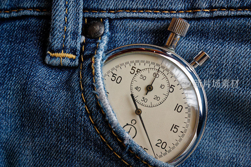 古董秒表，在旧旧破旧的深蓝色牛仔裤口袋里，测量时间的价值，旧时钟箭头分，秒精确计时记录