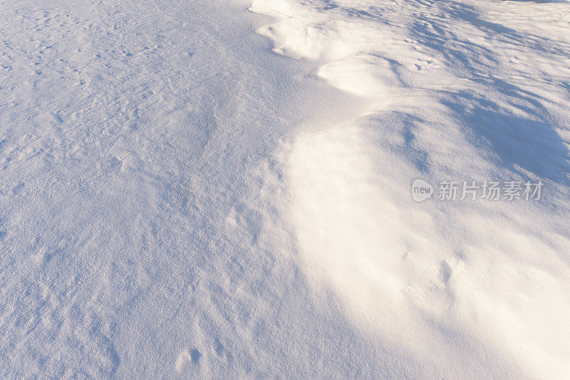 雪堆、风在雪面上雕刻出图案。