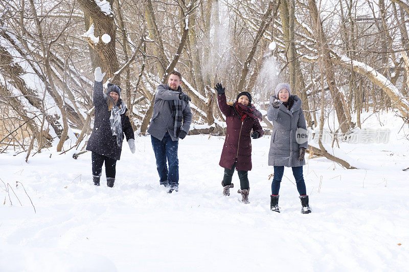 一群年轻人向照相机扔雪球