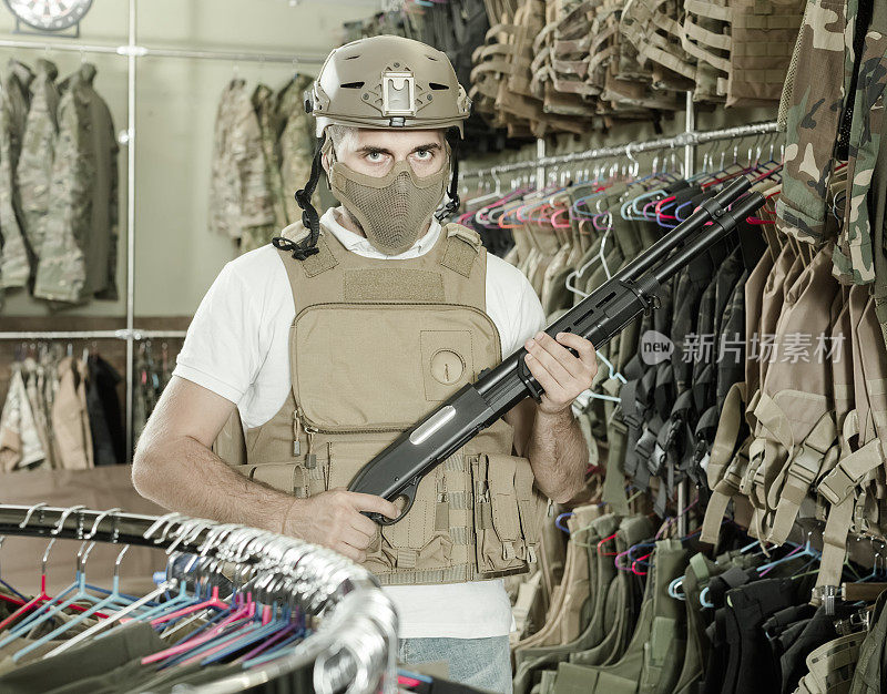 一个成年人在军队商店里拿着武器装备