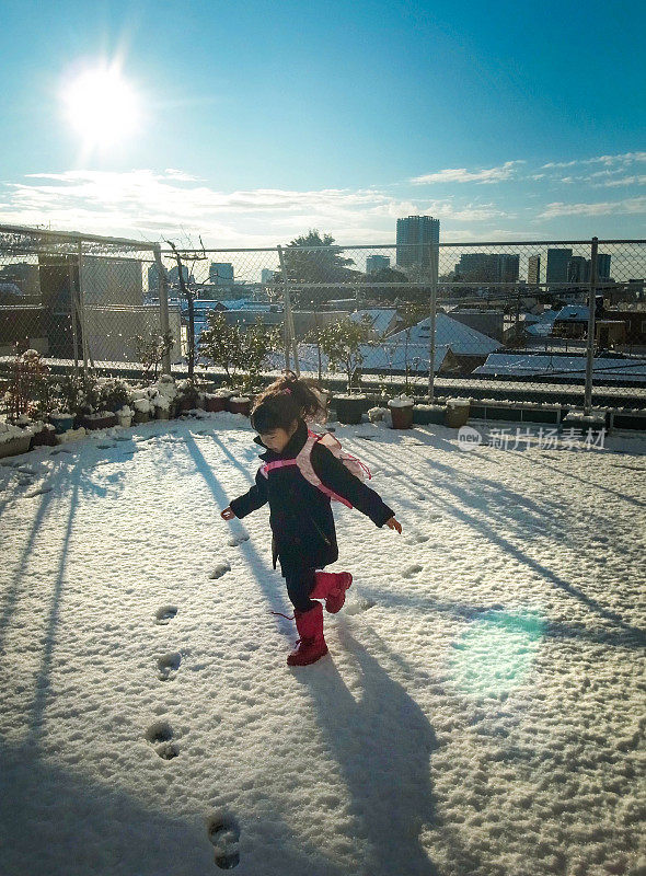 一个女孩微笑着在雪地上蹦跳。