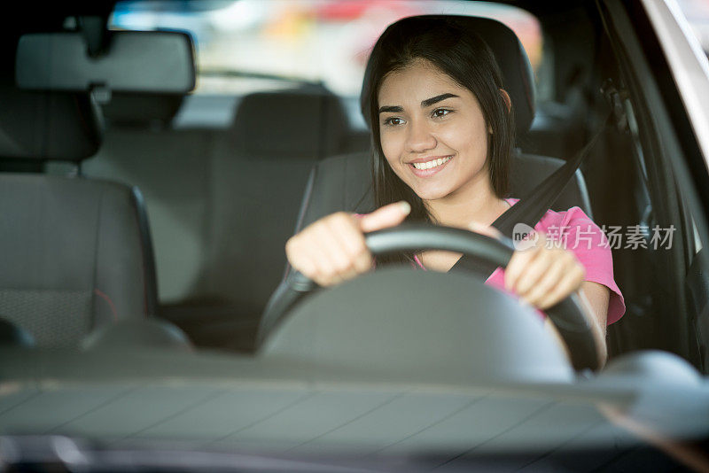 一个快乐的年轻女人开车的肖像