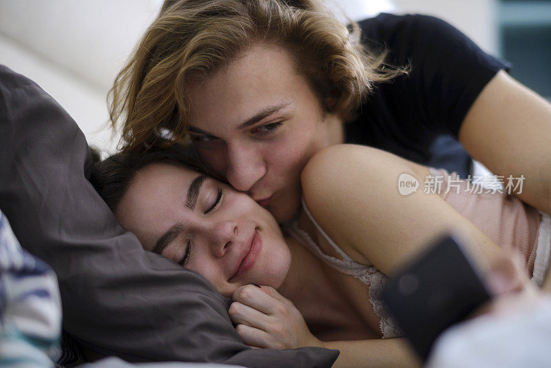 性感的年轻夫妇躺在床上的肖像