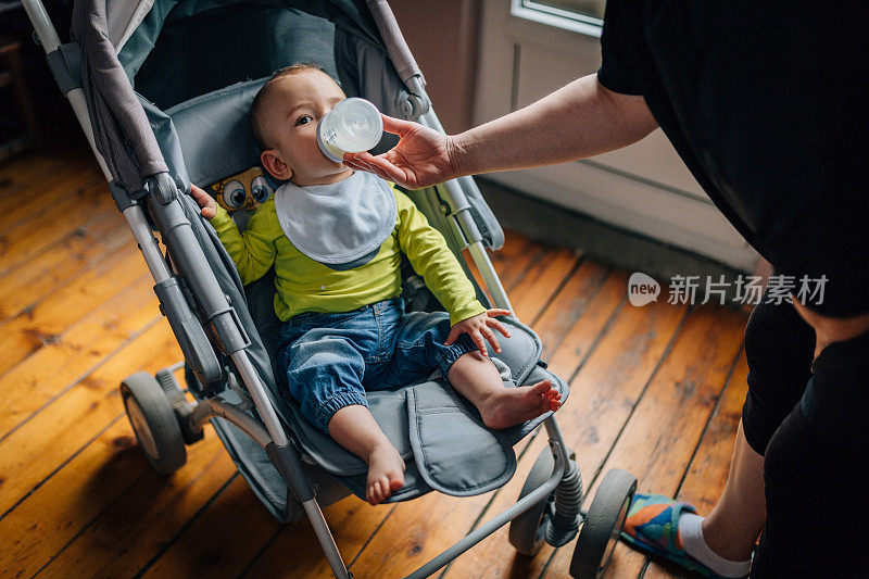 母亲用奶瓶喂她的男婴