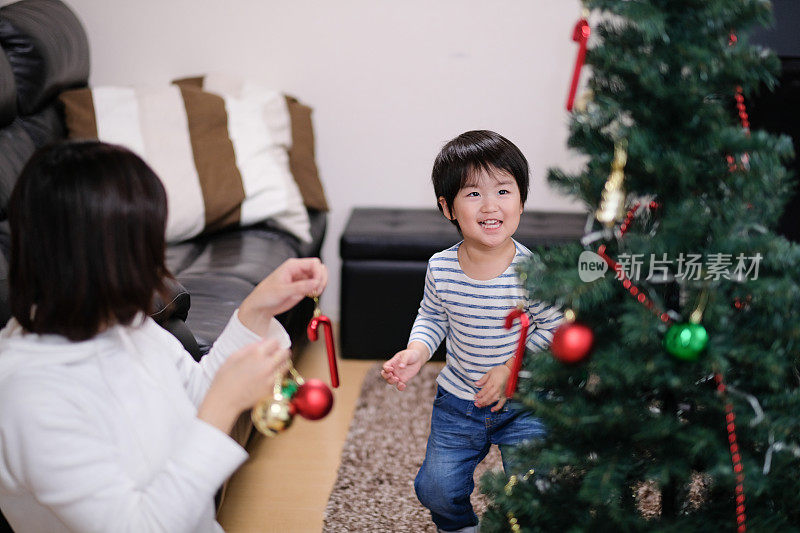 妈妈和孩子在家里装饰圣诞树