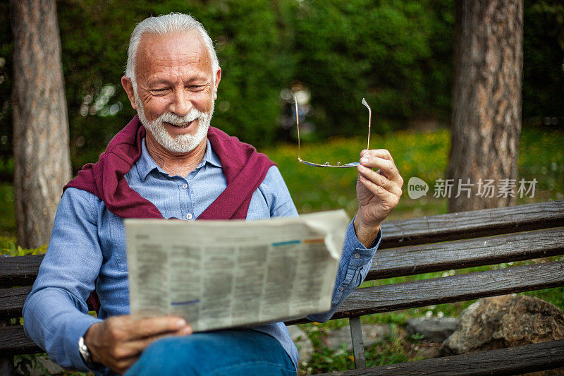 老人在公园里看报纸
