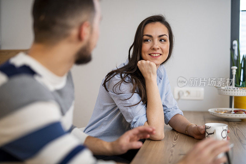 年轻夫妇坐在厨房喝茶