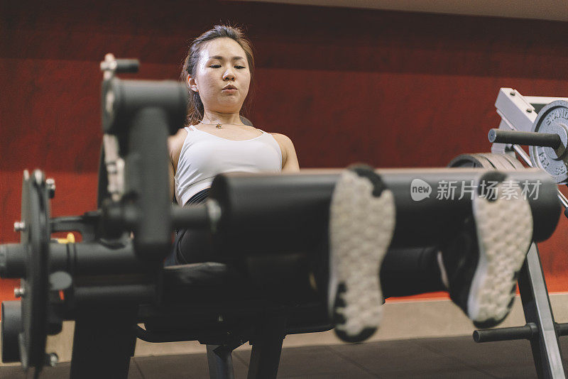 亚洲华人女性伸展腿在健身房锻炼