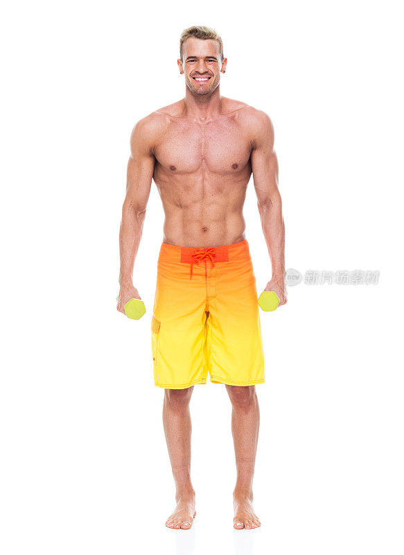 有吸引力的肌肉男人谁是赤膊和穿着冲浪短裤，是在锻炼