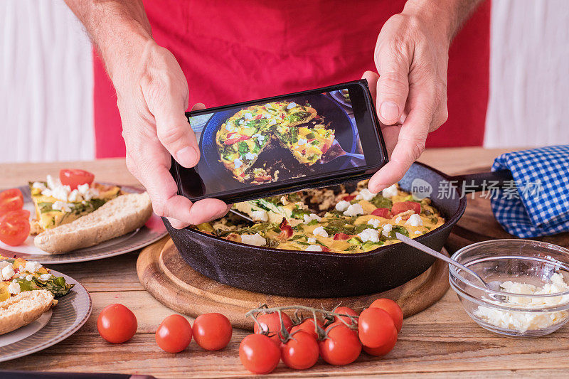 煎蛋饼配嫩菠菜、青椒、圣女果和山羊奶酪，用智能手机拍照