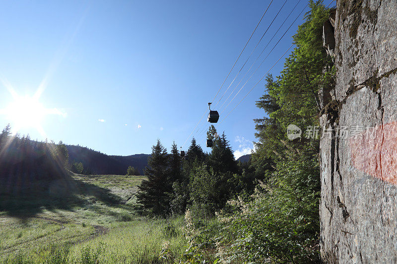 贡多拉在草地和岩面上方的山坡上移动