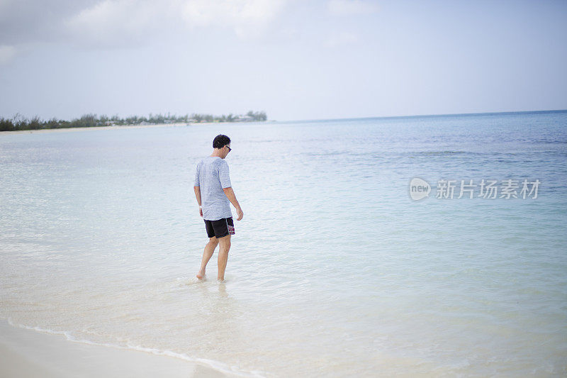 一个成熟的男人在海滩和加勒比海的绿松石海