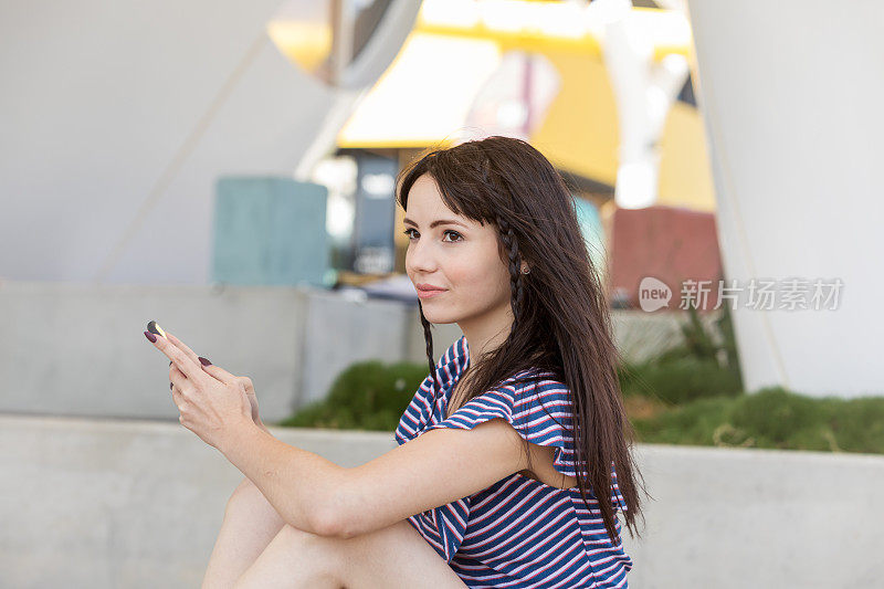 年轻女子在城市公园使用手机