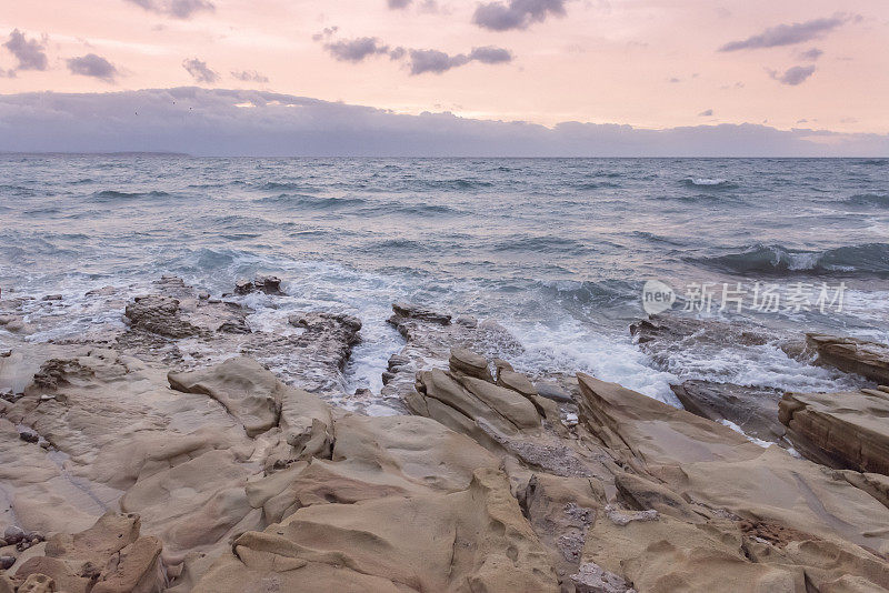 在冬天有风的一天，日出时爱琴海希腊岛的岩石海岸