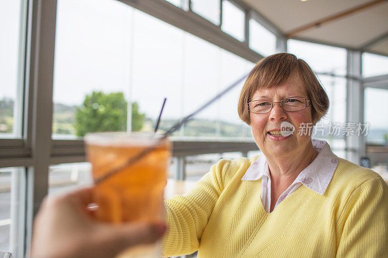 一位退休的职业女性出去吃午餐，和朋友举杯