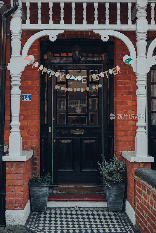 快乐的复活节花环在一个传统的爱德华时代的房子的正面在伦敦，英国，选择性的焦点。