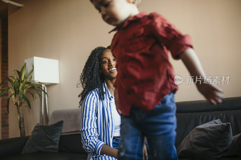 年轻的非洲妇女和孩子在走廊踢足球