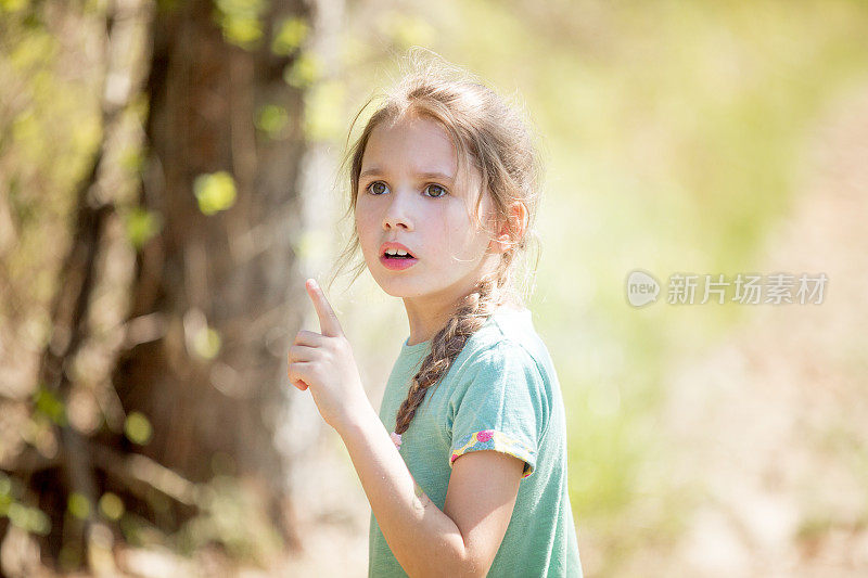 小女孩在森林里指着什么东西
