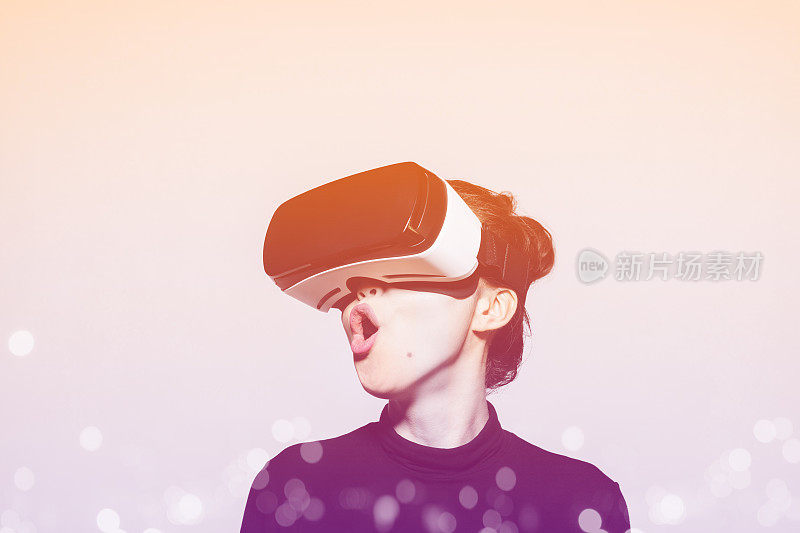 兴奋的年轻女子使用虚拟现实眼镜