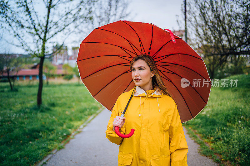 拿着红伞站在外面淋雨的女人