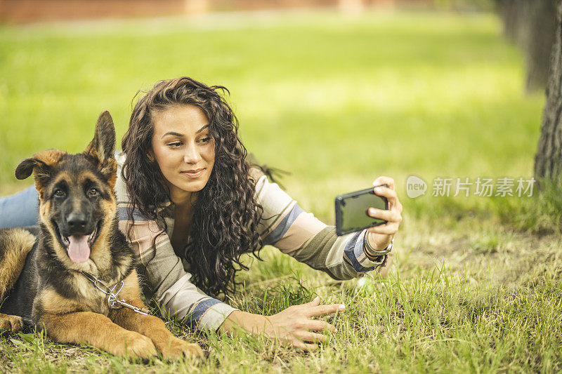 一个女人和她的狗在她的手机自拍