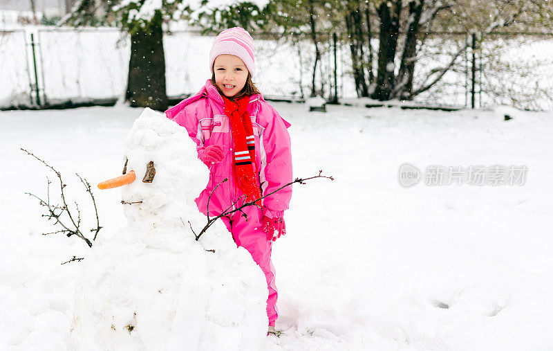 小女孩在院子里堆雪人