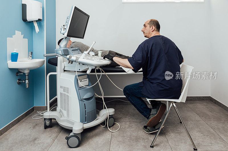 医生正在对躺在担架上的病人进行超声波扫描