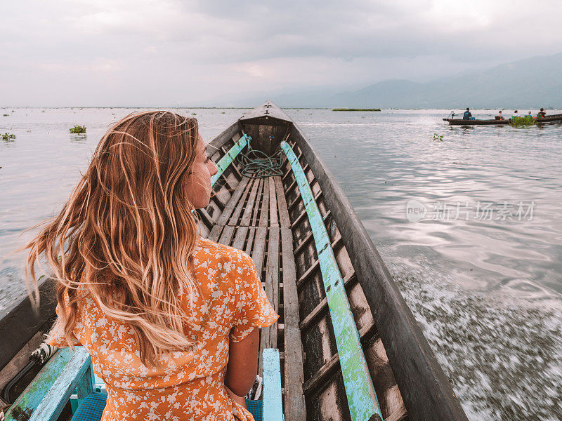 在缅甸茵莱湖上乘坐长尾船的妇女