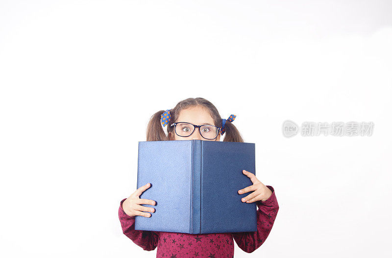 戴眼镜的聪明小女孩躲在书后面