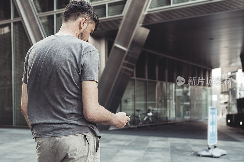 肘部有疤的男人拿着手机