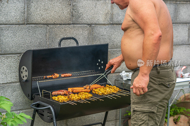 成熟的男人在后院烧烤