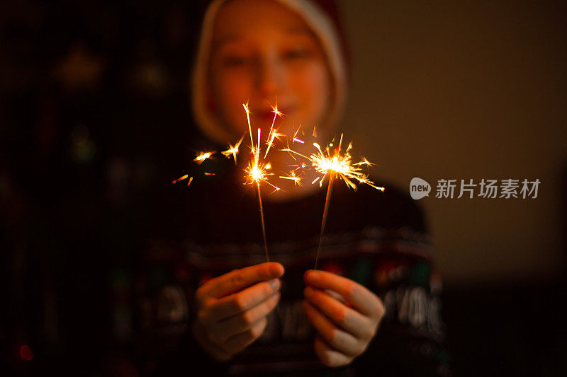 圣诞节或新年派对上拿着烟花的孩子。