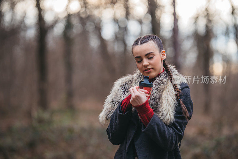 一个年轻漂亮的女人拿着热水瓶的肖像