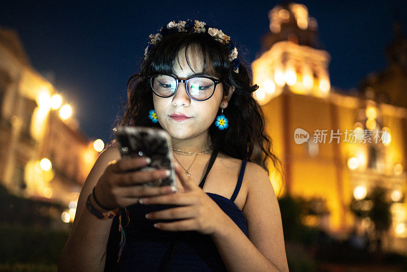 一名年轻女子在街上使用智能手机