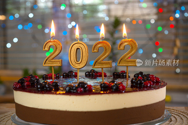 一个蜡烛上写着“2021”的蛋糕。