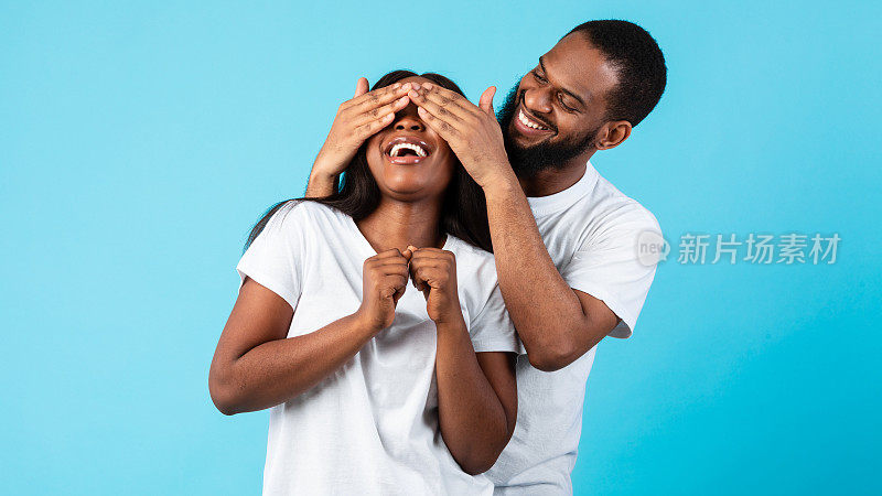 一个黑人男子蒙着他的女人的眼睛，给她一个惊喜