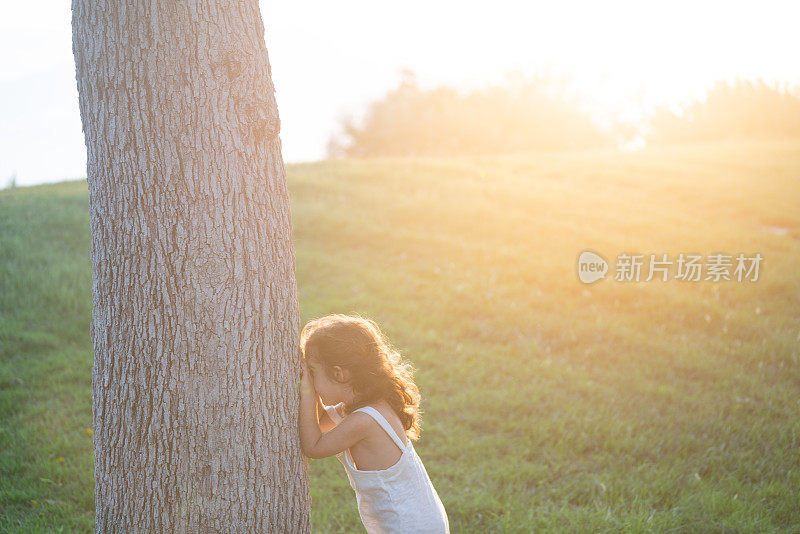 日落时分，女孩在公园里玩捉迷藏