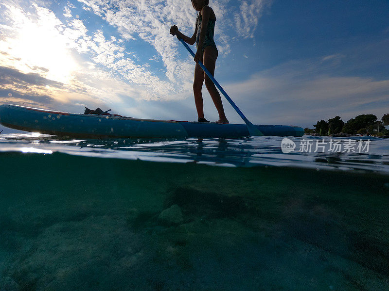 海中冲浪板上的女孩剪影