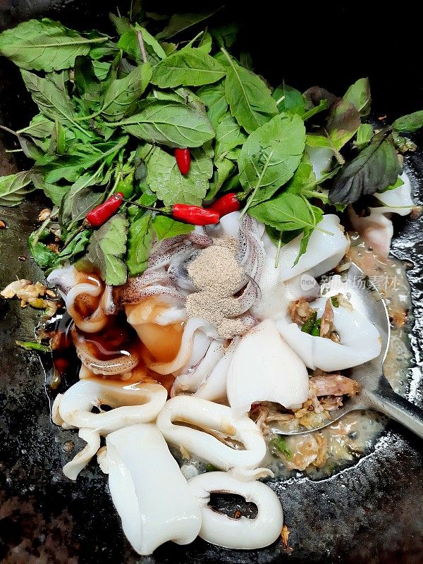 煮辣鱿鱼罗勒在煮锅-泰国菜的准备。