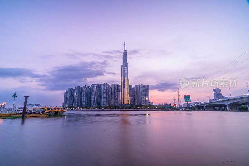 地标81的日落景象——这是一座超高的摩天大楼和西贡桥，西贡河沿岸的开发建筑灯光柔和下来。