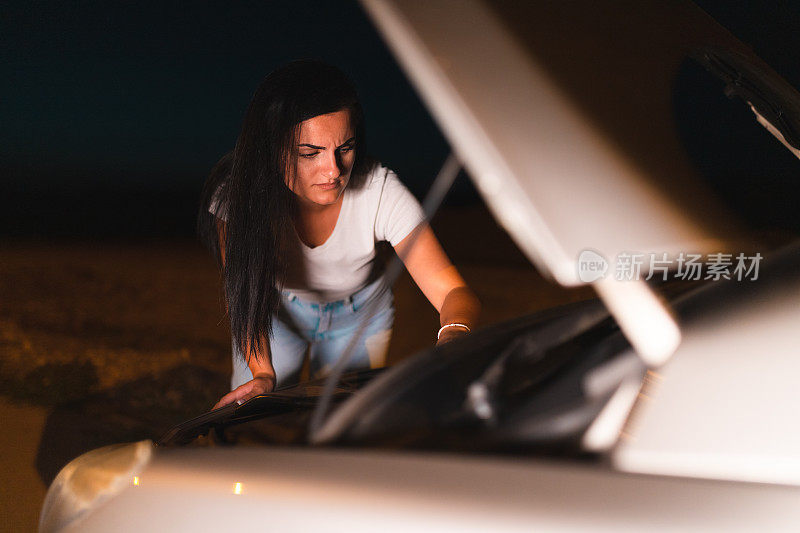 一位年轻女子在路边修汽车