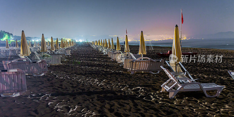 海上夜景照片。在欧洲旅行。意大利。雨伞在海岸上。在海滩上放松的地方。美丽的风景。《暮光之城》。温暖的夜晚。