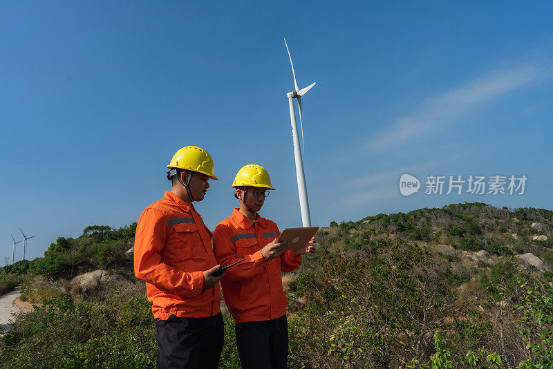 电力工程师使用平板记录风电场运行情况