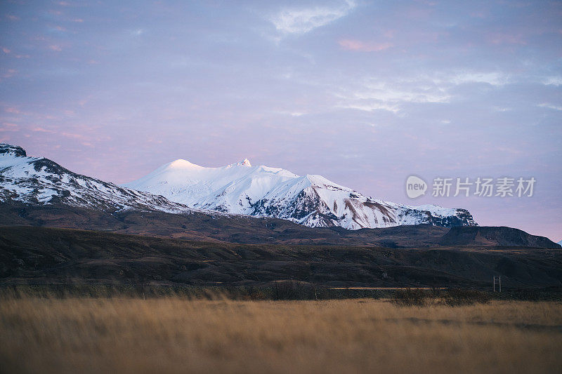 白雪皑皑的山峦和草地上的日出