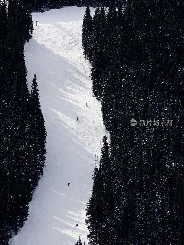 陡峭的mogul滑雪场和滑雪者的长焦视图。阿斯彭高地滑雪场。美国科罗拉多州的阿斯彭。