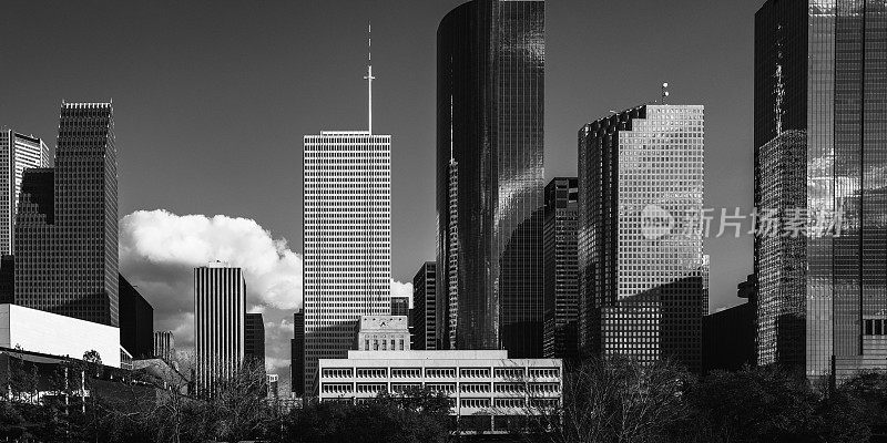复古风格的黑白相间的德克萨斯州休斯顿市中心建筑和城市天际线，在大都市高速公路上有戏剧性的云