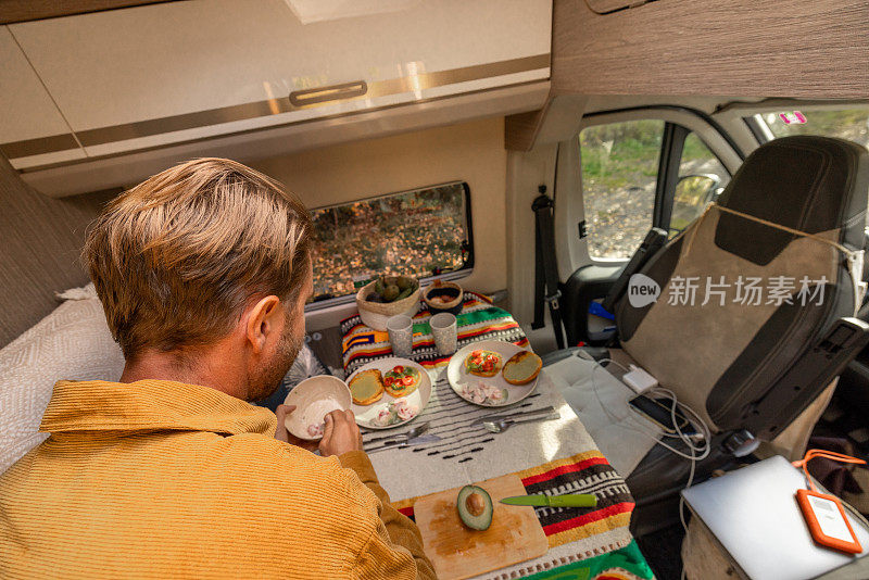 一名男子在他的露营车里准备食物。露营的概念