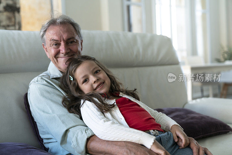 老人和孙女坐在家里沙发上的照片